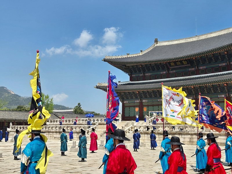 The royal guard changing ceremony in costume with banners raised at the palace gate